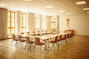 ein großer Konferenzraum mit einem langen Tisch und Stühlen in der Unterkunft Kloster St. Josef in Neumarkt in der Oberpfalz