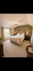 a bedroom with a large bed and a window at Corrib View Country House in Killarone