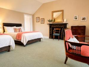 a bedroom with two beds and a mirror and a chair at Corrib View Country House in Killarone
