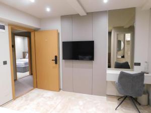 a room with a tv and a chair in a room at SFERA Boutique Rooms in Iaşi
