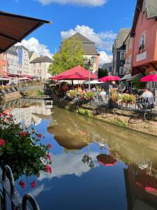 a river in a town with tables and chairs and buildings at Ferienwohnung Zum Geisberg in Ockfen