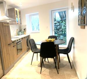 a kitchen and dining room with a table and chairs at Le Mas des Sources - Appartement in Vals-les-Bains