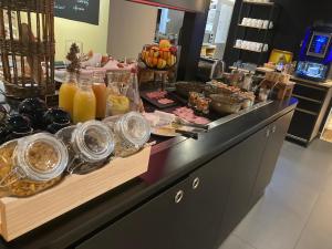 a buffet with glasses of orange juice and other food at Kyriad Blois Nord in Blois