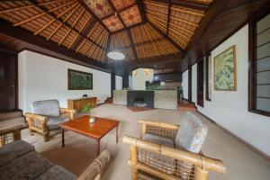 a living room with chairs and a table and a fireplace at The Buyan Resort Bedugul in Bedugul