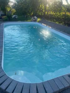 a large swimming pool with blue water at Nyúlászó Vendégház Stúdiólakás in Mád