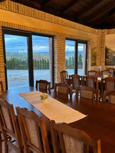 a dining room with a table and chairs and windows at Camere de inchiriat Adyden in Arbore