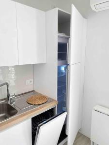 a kitchen with white cabinets and a pizza on a counter at Studio Artemisia in Grado
