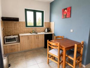 a kitchen with a wooden table and a microwave at 4Seasons Sfakia in Hora Sfakion +12 photos