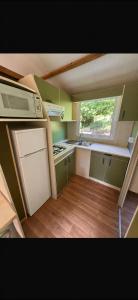 a small kitchen with a stove and a window at Chalet en Corse in Santa-Maria-Figaniella