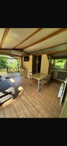 a room with a table and chairs on a wooden floor at Chalet en Corse in Santa-Maria-Figaniella