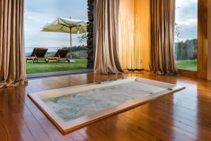 a room with a bath tub on a wooden floor at Monaci delle Terre Nere in Zafferana Etnea +129 photos