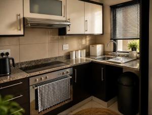 a kitchen with a sink and a stove top oven at Beach, Restaurants, Shopping, Park, Pier - nearby in Durban