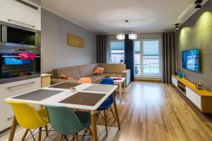 - un salon avec une table, des chaises et un canapé dans l'établissement Apartament Waterside, à Giżycko