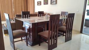 a kitchen with a island with chairs around it at Luxury Chalet Villa in Shimla