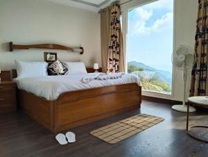 a bedroom with a bed and a large window at Luxury Chalet Villa in Shimla