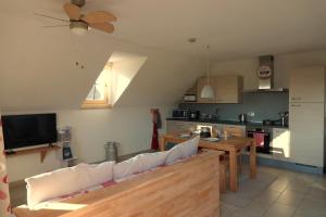 a living room with a couch and a kitchen at Gîte La Grange in Chapelle