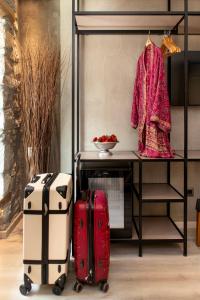 two pieces of luggage sitting next to a table with a coat at Evoras Boutique Hotel in Xirokámbion