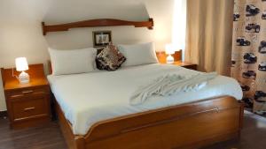 a bedroom with a bed with white sheets and two lamps at Luxury Chalet Villa in Shimla
