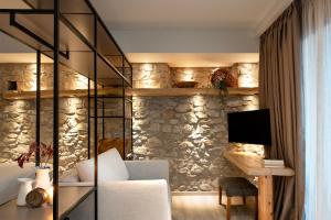 a living room with a stone wall at Evoras Boutique Hotel in Xirokámbion