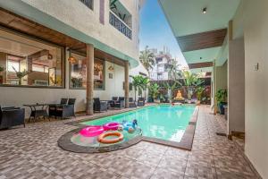 an indoor swimming pool in a house with a restaurant at Le Seasons Resort in Candolim