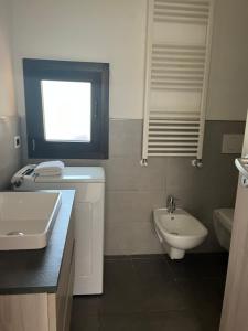 a bathroom with a sink and a toilet and a window at Appartamento sole e luna in Dumenza