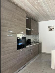 a kitchen with wooden cabinets and a stove at Appartamento sole e luna in Dumenza +7 photos