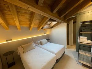 a bedroom with a large white bed with a wooden ceiling at Hotel SPA John Te Lo Busca in Castrojeriz +28 photos