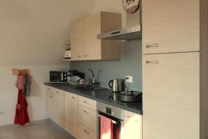a kitchen with a sink and a stove top oven at Gîte La Grange in Chapelle +12 photos