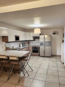 a kitchen with a table and chairs and a refrigerator at Maison de campagne in Aubagne