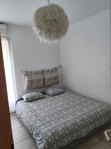 a bedroom with a bed and a chandelier at Maison de campagne in Aubagne
