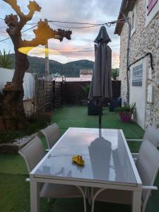 a table and chairs on a patio with an umbrella at Maison de campagne in Aubagne