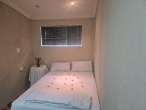 a small room with a bed with red hearts on it at Graceful Seniors in Durban