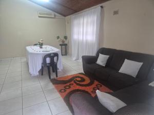 a living room with a table and a couch at Graceful Seniors in Durban