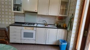 a kitchen with white cabinets and a sink at Casa Carmela in Sapri +1 photo
