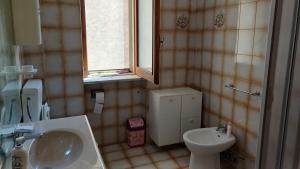a bathroom with a sink and a toilet and a window at Casa Carmela in Sapri