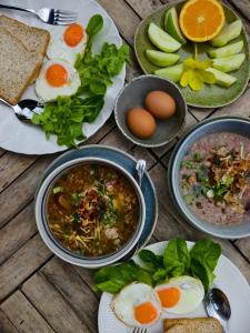 a table topped with plates of food with soup and eggs at Wave & Vibes Koh chang in Ban Chek Bae (1)