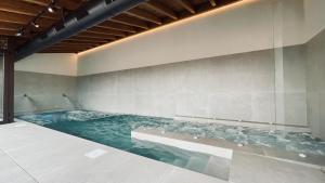 a large swimming pool with blue water in a room at Hotel SPA John Te Lo Busca in Castrojeriz