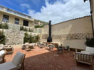 a patio with chairs and tables and a stone wall at Hotel SPA John Te Lo Busca in Castrojeriz