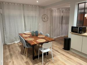 a dining room with a wooden table and chairs at Châtelaines 59 in Avallon