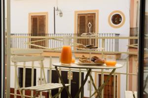 a table with a plate of food and orange juice at Casa Boutique Con Terraza Ideal in Dos Hermanas