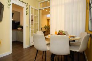 a dining room with a table and white chairs at Casa Boutique Con Terraza Ideal in Dos Hermanas