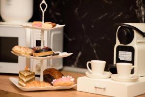 a table with two tiers of pastries and cups of coffee at Casa Boutique Con Terraza Ideal in Dos Hermanas +32 photos