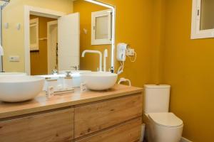 a bathroom with two sinks and a toilet at Casa Boutique Con Terraza Ideal in Dos Hermanas