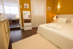 a bedroom with a large white bed with towels on it at Casa Boutique Con Terraza Ideal in Dos Hermanas