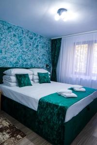 a bedroom with a large bed with a blue wall at Dey Villa, Valea Avrigului, Transilvania in Avrig