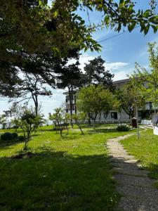 a path through a park with trees and a building at Casa Scriitorilor in Olimp