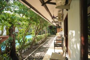 a porch of a house with chairs and a pool at Pondok IJo Guesthouse in Yogyakarta