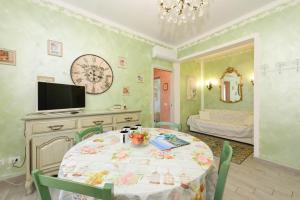 a dining room with a table and a tv and a bedroom at Le Bouganville Apartment- Downtown & close to the beach in Desenzano del Garda