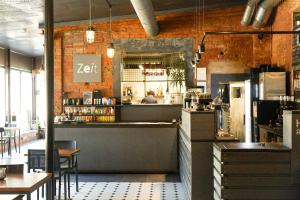 eine Bar in einem Restaurant mit einer Person im Spiegel in der Unterkunft Zeit Hotel in Līgatne