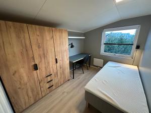 a bedroom with a bed and a desk and a window at Flott sommerhus midt i Lillehammer sentrum in Lillehammer